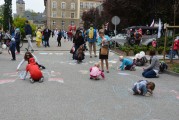 dzieci malują kredą po chodniku