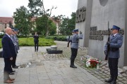 Wojewoda wraz z komendantami policji stoją przed pomnikiem Czerwca 56. 