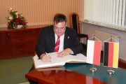 Sekretarz Stanu ds. Europejskich Hesji wpisuje się do księgi pamiątkowej.   