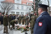 Uczestnicy uroczystości składają kwiaty. 