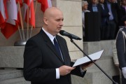 wojewoda przemawia na tle flag narodowych