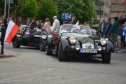 czarne kabriolety z flagami wjeżdżają na parking