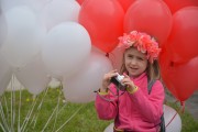 dziewczynka na tle białych i czerwonych balonów