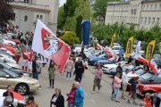 duża flaga zespołu sportowego powiewa nad parkingiem z kabrioletami