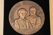 okrągły medal w pudełku z podobizną Paderewskiego i Tpoczubaszewa