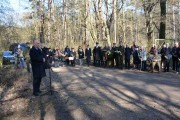 Wojewoda zabiera głos przed uroczystością złożenia kwiatów pod głazem. 