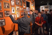 Przewodnik opowiada młodzieży o wystawie ukazującej powstanie wielkopolskie.