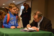 Andrzej Maleszka podpisuje chłopcu swoją książkę. 
