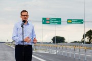 Premier przemawia na tle drogi