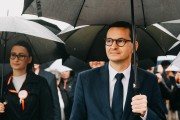 Premier stoi podczas Mszy Świętej, w tle kobieta