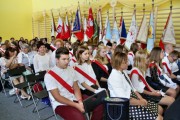Uczniowie siedzący w sali gimnastycznej.