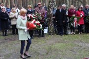 Kierownik delegatury WUW w Kaliszu składa kwiaty przy obelisku ofiar.