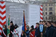 Młodzież szkolna na tle wystawy historycznych fotografii. 