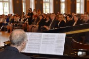 Występ muzyczny. W tle uczestnicy uroczystości. 