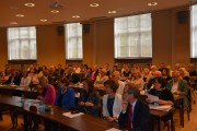 Uczestnicy konferencji siedzą w sali. 