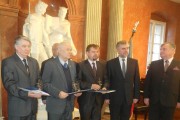 Marszałek Województwa Marek Woźniak stoi z laureatami. 