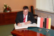 Sekretarz Stanu ds. Europejskich Hesji wpisuje się do księgi pamiątkowej.   