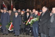 Goście uroczystości z kwiatami przed Pomnikiem Polskiego Państwa Podziemnego i AK. 