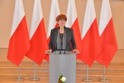 Wystąpienie minister Rafalskiej. W tle biało-czerwone flagi. 