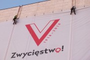 Alpiniści na tle logo Zwycięstwo.