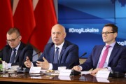Premier z ministrami przed wyświetlaczem.
