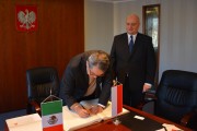 Ambasador Meksyku wpisuje się do księgi pamiątkowej. 
