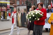 Kobiety trzymają portret śp. pary prezydenckiej podczas przemarszu.