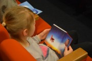 Dziewczynka ogląda książkę autorstwa Andrzeja Maleszki.