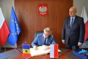 Ambasador Mołdawii wpisuje się do księgi pamiątkowej.