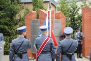Sztandar przed pomnikiem pomordowanych policjantów