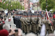 Uczestnicy obchodów robią zdjęcia maszerującym żołnierzom