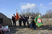 Grupa uczestników obchodów obok obelisku