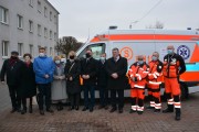 Wspólne zdjęcie uczestników uroczystości przy ambulansie