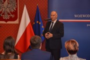 Poseł Tadeusz Dziuba przemawia, przed nim siedzą zaproszeni goście.