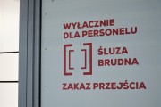 Napis na drzwiach: Wyłącznie dla personelu. Śluza brudna. Zakaz przejścia