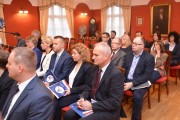 Dyrektorzy urzędu siedzą w sali podczas konferencji. 