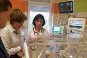Wicewojewoda patrzy na inkubator z noworodkiem. 