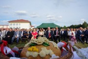 Chleb dożynkowy, w tle goście