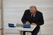 Gość uroczystości wpisuje się do księgi