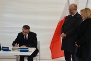 Gość uroczystości wpisuje się do księgi
