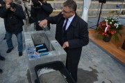 Gość uroczystości zamurowuje kamień węgielny
