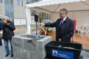 Gość uroczystości zamurowuje kamień węgielny