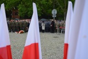 Widok uczestników uroczystości zza flag narodowych. 