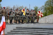 Grupa rekonstruktorów historycznych stoi na stopniach pomnika Armii Poznań