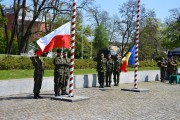 Wciąganie polskiej flagi na masz, obok poczet sztandarowy i flaga Rumunii.