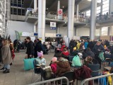 kolejka grupy uchodźców w holu głównym punktu recepcyjnego na MTP 2