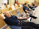 Policjant na leżance w trakcie oddawania krwi.