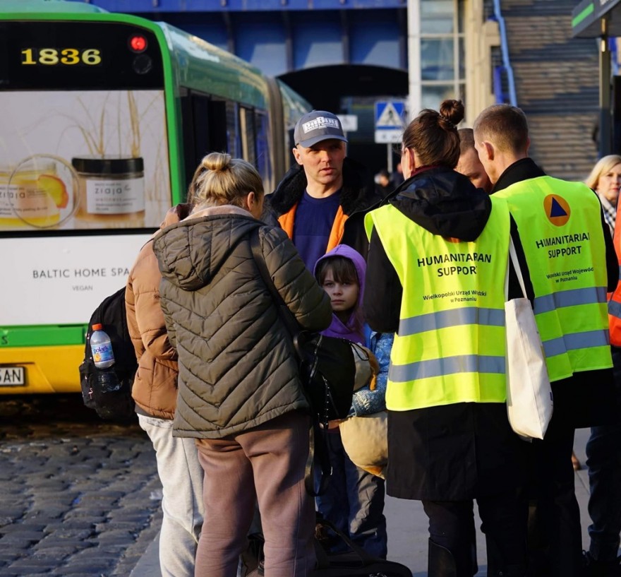 kobiety z dzieckiem rozmawiają z policjantami oraz wolontariuszami urzędu wojewódzkiego