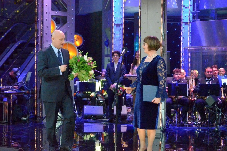 Wojewoda wręcza kwiaty dyrektor poznańskiego oddziału TVP. 