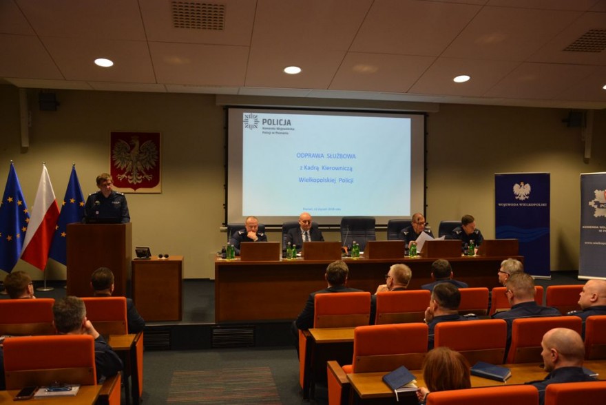 Widok ogólny na salę sesyjną, cztery osoby za stołem prezydialnym